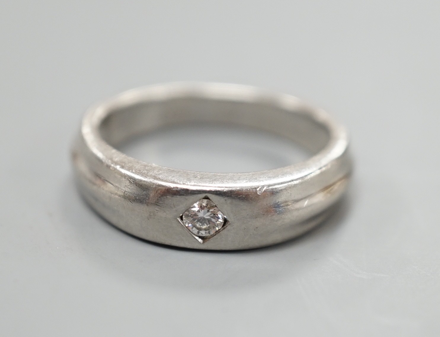 A modern platinum and gypsy set solitaire diamond ring, size K, 6.6 grams.